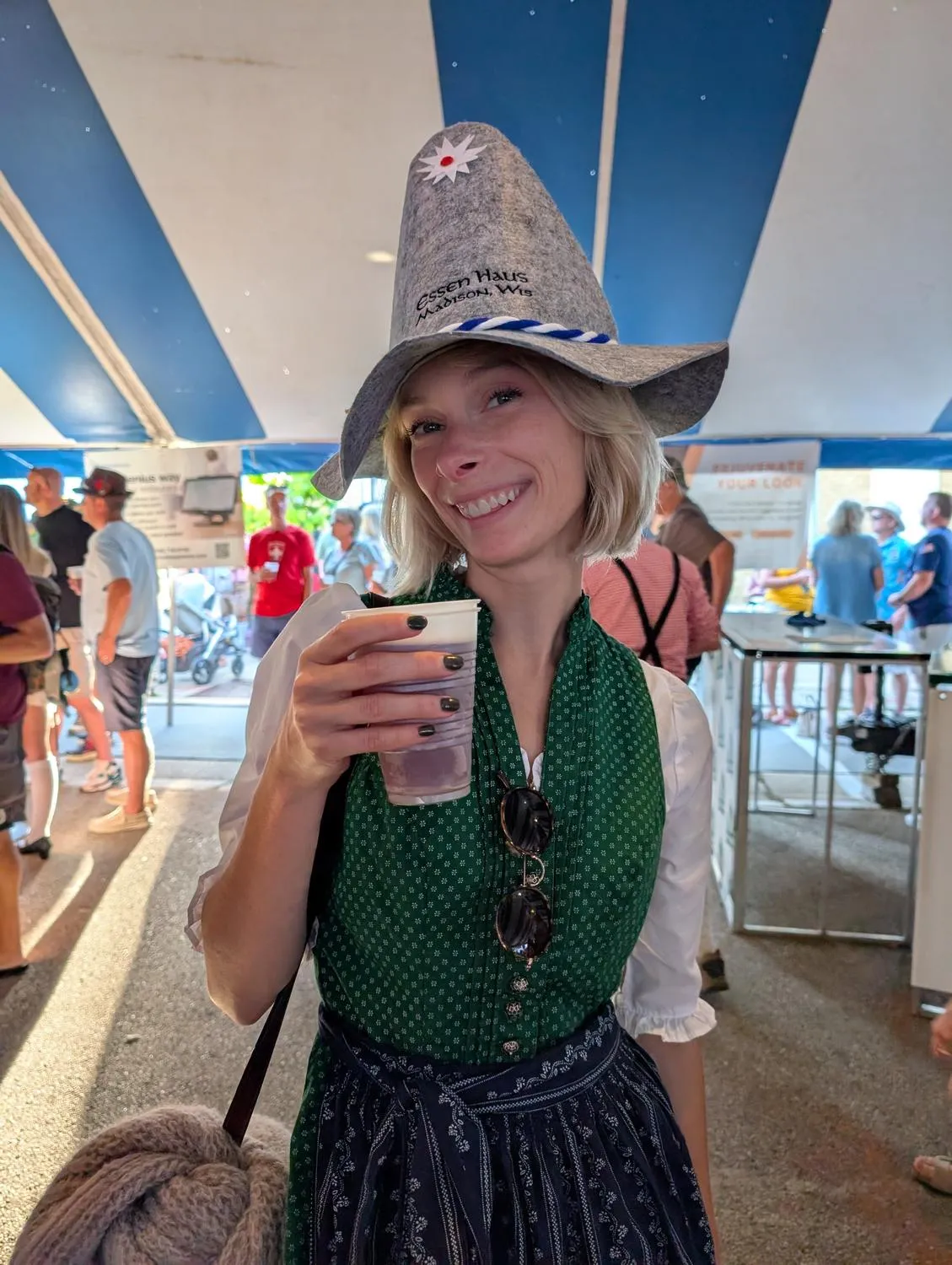 Ashley outside the New Glarus brewery, holding a beer.